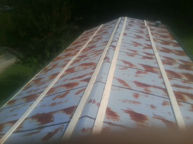 Rusted metal roof panels with new wood purlins before replacement — Storm Damage Roof Repair in Aliceville by Roofing Brothers
