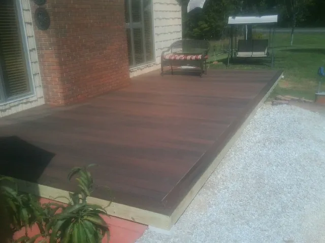 Freshly stained wood deck built against a brick home in Aliceville