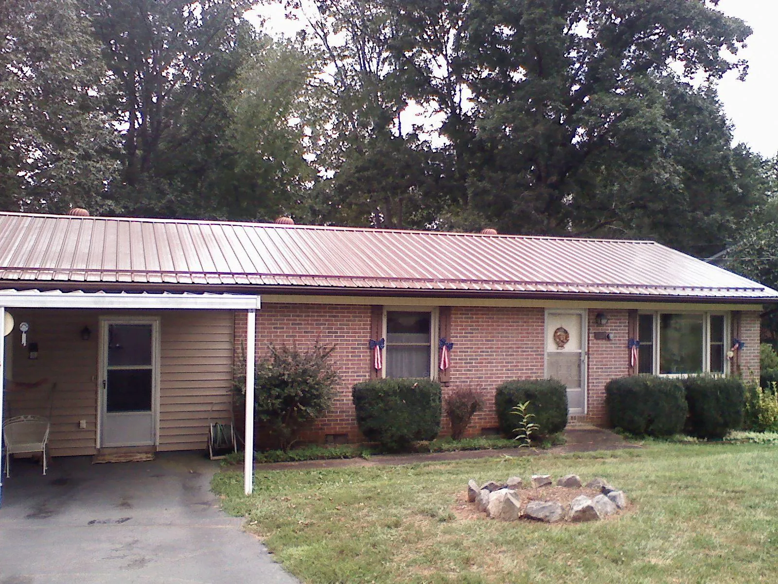Bronze metal roof and carport on a brick ranch home — Roof Repair work by our crew in Aliceville